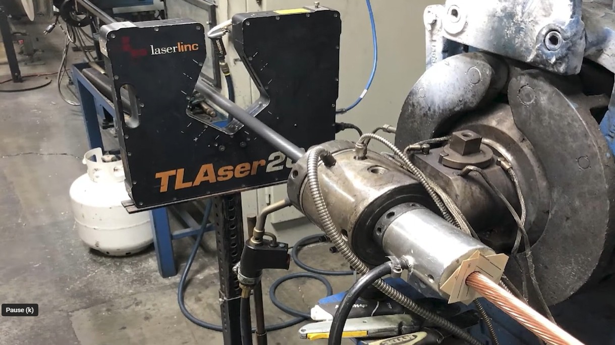 Inline laser micrometer measuring wire beside an extrusion crosshead