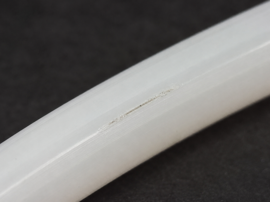 Localized scratch on opaque medical tubing requiring a defined inspection method